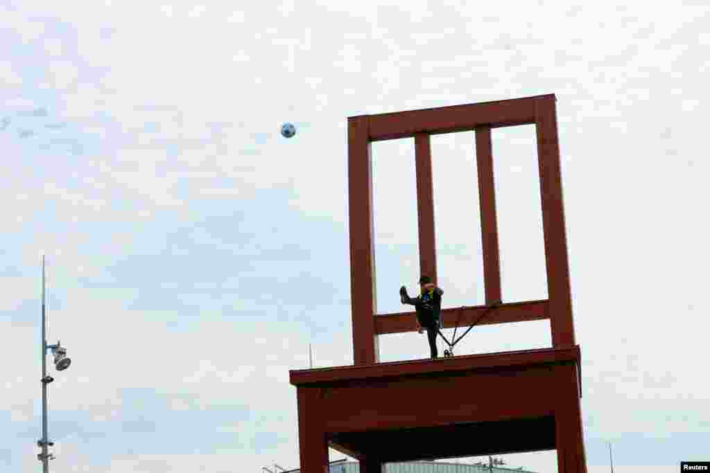 Newly appointed Goodwill Ambassador for Handicap International, and Paris Saint-Germain's star soccer player, Neymar, kicks the ball from the "Broken Chair," which was made by Daniel Berset, and symbolizes opposition to land mines and cluster bombs in front of the United Nations in Geneva, Switzerland.