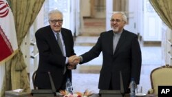 Menlu Iran Mohammad Javad Zarif (kanan) dalam konferensi pers bersama utusan PBB-Liga Arab untuk Suriah Lakhdar Brahimi (foto: dok). Iran belum diundang untuk ikut perundingan Suriah. 