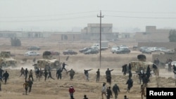 Masu zanga-zanga kennan a lokacin da suke jifar dakarun Iraki da duwatsu a garin Falluja dake Iraq, January 25, 2013.