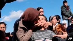 Dilbar Ali Ravu, 10, is kissed by his aunt Dalal Ravu after Yazidi children were reunited with their families in Iraq after five years of captivity with the Islamic State group, March 2, 2019. 