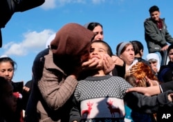 FILE - Dilbar Ali Ravu, 10, is kissed by his aunt Dalal Ravu after Yazidi children were reunited with their families in Iraq after five years of captivity with the Islamic State group, March 2, 2019.