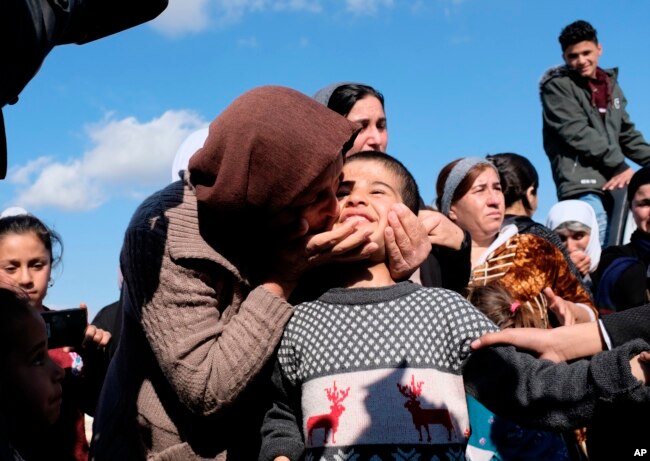 FILE - Dilbar Ali Ravu, 10, is kissed by his aunt Dalal Ravu after Yazidi children were reunited with their families in Iraq after five years of captivity with the Islamic State group, March 2, 2019.