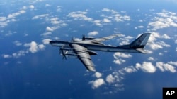 FILE - In this photo provided by Britain's Royal Air Force and taken on Oct. 29, 2014, a Russian military long range bomber aircraft photographed by an intercepting RAF quick reaction Typhoon (QRA) flies in international airspace. 