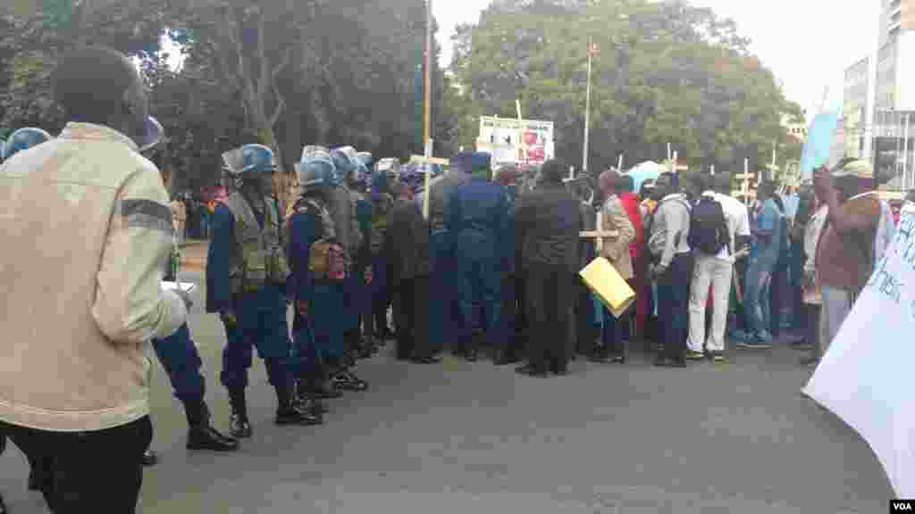 Police attempt to block protesters in Harare.