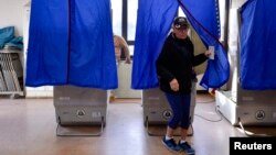 FILE - A voter leaves a polling booth during the U.S. presidential election in Philadelphia, Pennsylvania, Nov. 8, 2016. Most units lack paper records needed to check for fraud and errors, according to a report released Tuesday.