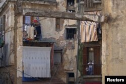 Children stand on the balcony near remains of a collapsed moorish house in the old city of Algiers Al Casbah, Algeria, Dec 9, 2015.