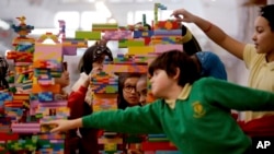 Children from the local Globe Primary School help build a Lego sculpture during a photocall to promote the exhibition "The Century of the Child: Nordic Design for Children 1900 to Today" at the V&A Museum of Childhood in east London, Monday, March 19, 201