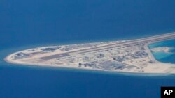 Chinese structures and an airstrip on the man-made Subi Reef at the Spratly group of islands in the South China Sea are seen from a Philippine Air Force C-130 transport plane of the Philippine Air Force, April 21, 2017. The South China Sea issue is expect