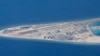 FILE - Chinese structures and an airstrip on the man-made Subi Reef at the Spratly group of islands in the South China Sea are seen from a Philippine Air Force C-130 transport plane of the Philippine Air Force, April 21, 2017.