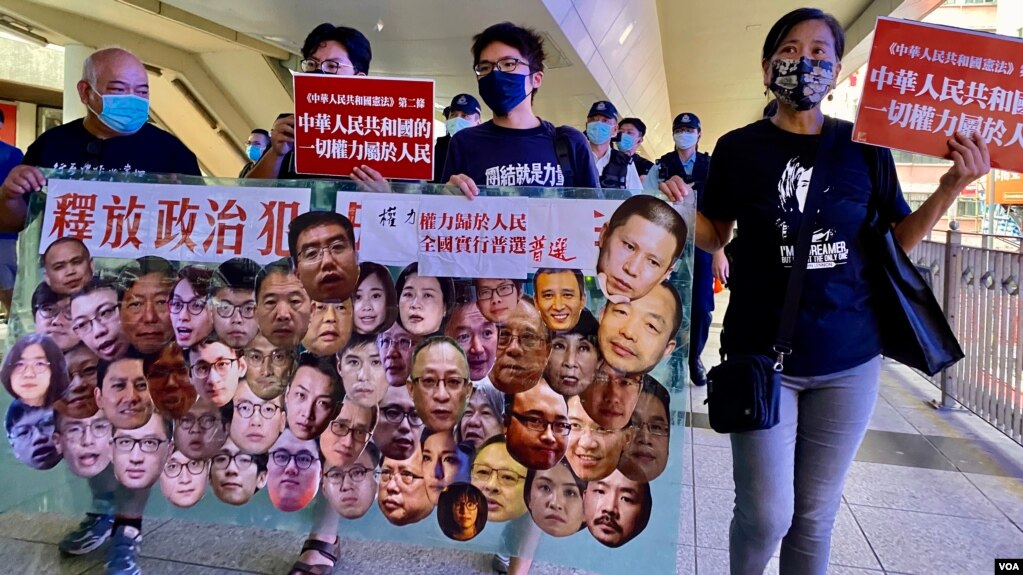 香港社民连主席陈宝莹(右起)与外务副主席周嘉发、成员余炜彬及前东区区议员曾健成，在十一中国国庆日游行，要求全中国实行普选、释放所有政治犯 (美国之音/汤惠芸)