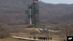 Un grupo de periodistas regresa de la visita a la plataforma de lanzamiento del cohete Unha en Corea del Norte.