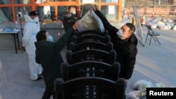 FILE - A worker delivers food to residents under lockdown following the coronavirus disease (COVID-19) outbreak in Xian, Shaanxi province, China Dec. 29, 2021.