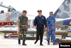 Presiden Indonesia Joko Widodo (tengah) bersama Panglima TNI Gatot Nurmantyo (kiri) dan Panglima TNI Agus Supriatna berjalan melewati jet tempur dan senjata saat latihan militer di Pulau Natuna, Provinsi Kepulauan Riau, 6 Oktober 2016. (Foto: Reuters)