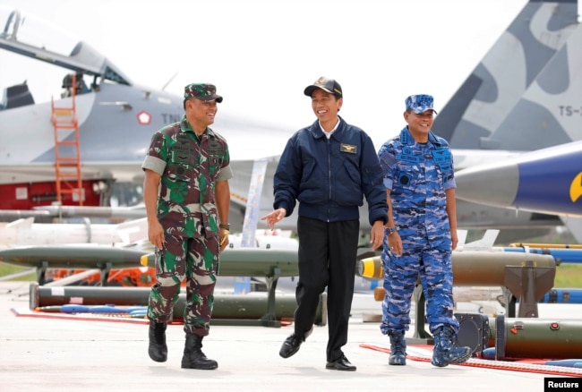 Presiden Indonesia Joko Widodo (tengah) bersama Panglima TNI Gatot Nurmantyo (kiri) dan Panglima TNI Agus Supriatna berjalan melewati jet tempur dan senjata saat latihan militer di Pulau Natuna, Provinsi Kepulauan Riau, 6 Oktober 2016. (Foto: Reuters)