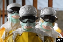 Health care workers in protective suits leave a high-risk area at a Monrovia hospital run by Doctors Without Borders on Aug. 30, 2014.