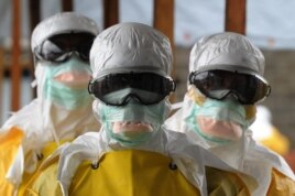 Health care workers in protective suits leave a high-risk area at a Monrovia hospital run by Doctors Without Borders on Aug. 30, 2014.