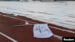 Một lá cờ mang logo Thế vận hội Mùa đông 2018 nằm trên mặt đất tại một địa điểm được đề xuất xây sân vận động Olympic ở Pyeongchang, 10/2/2015.