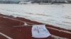 FILE - A flag bearing the logo of 2018 Winter Olympic Games lies on the ground at the proposed site of the Olympic Stadium near the Alpensia Resort in the mountain cluster of PyeongChang.