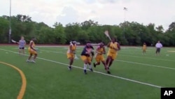 Some of the girls on the lacrosse team at Ballou High School in Washington, D.C., run a drill on the practice field, May 2011