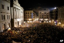 Demonstrators holding banners reading in Catalan "Freedom for the political prisoners" gather at the Barcelona town hall, during a protest against the decision of a judge to jail ex-members of the Catalan government, in Barcelona, Spain, Nov. 3, 2017.