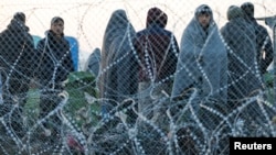 Para migran yang ditolak untuk masuk ke Makedonia menunggu di Idomeni, Yunani, Selasa (23/2). 