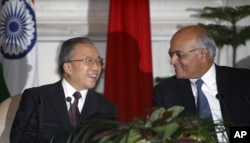 Chinese State Councilor and Special Representative on the Boundary Question, Dai Bingguo (L) and Indian National Security Adviser Shivshankar Menon smile after signing an agreement in New Delhi, India, January 17, 2012.