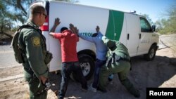 Border Patrol agents arrest migrants who crossed the U.S.-Mexico border in the desert near Ajo, Arizona, Sept. 11, 2018. 