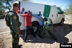 FILE - Border Patrol agents arrest migrants who crossed the U.S.-Mexico border in the desert near Ajo, Arizona, Sept. 11, 2018.