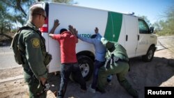 La police des frontières interpelle des migrants qui ont traversé la frontière américano-mexicaine dans le désert près d'Ajo, en Arizona, le 11 septembre 2018.