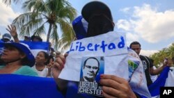 Manifestantes sostienen carteles que exigen la liberación de presos políticos en Managua, Nicaragua.