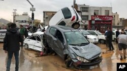 Vehicles are piled up on a street after a flash flood in the southern city of Shiraz, Iran, March 25, 2019.