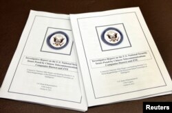 FILE - The House Intelligence Committee's report on "national security threats posed by Chinese telecommunications companies Huawei and ZTE" is seen at a news conference on Capitol Hill in Washington, Oct. 8, 2012.