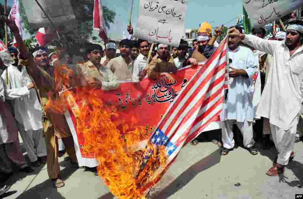 18일 파키스탄 폐샤와르에서 수니파 급진 교도들이 미국에서 만들어진 이슬람 관련 영화에 항의해 미국 국기인 성조기를 불태우고 있다.