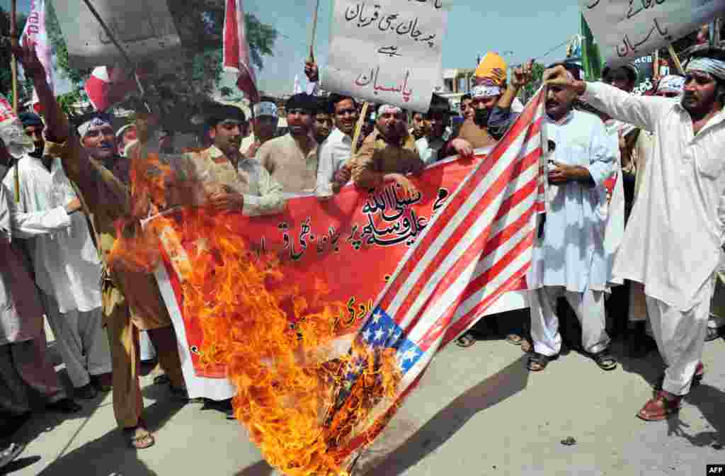 Koox cadheysan oo ka tirsan xisbiga Sunniga ee Jamaat-e-Islami (JI) ee Pakistan oo gubaya calanka Maraykanka,Peshawar, September 18, 2012. 