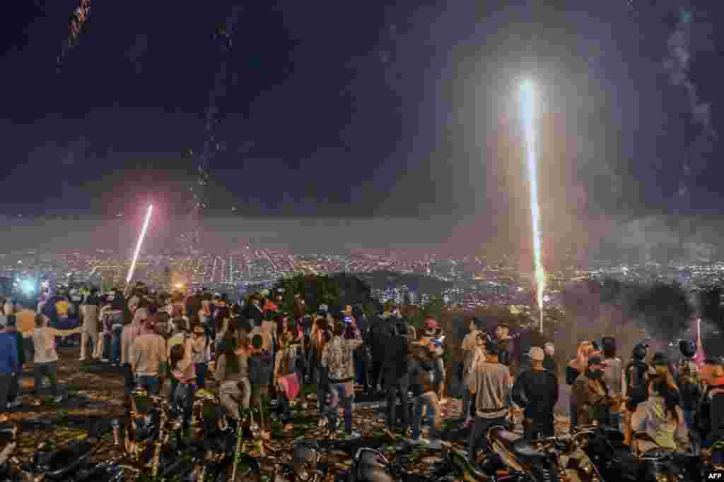 People watch fireworks during the Alborada, a tradition to celebrate the arrival of the Christmas season, in Medellin, Colombia, Dec. 1, 2020.