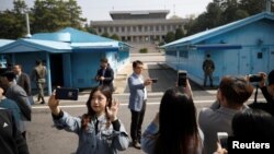 한국 정부가 1일 비무장화된 판문점 공동경비구역(JSA) 안보견학을 시작한 가운데, 방문객들이 기념사진을 찍고 있다.