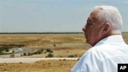အစ္စရေးဝ်ကြီးချုပ်ဟောင်း Ariel Sharon Nitzanim ဂျူးအခြေချနေထိုင်သူ ထောင်ပေါင်းများစွာ နေထိုင်ဖို့ ရည်မှန်းထားတဲ့ ကမ်းမြောင်ဒေသကို ကြည့်နေစဉ်။ (မေ ၁၇၊ ၂၀၀၅)
