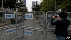 A journalist shoots video behind barriers blocking the road leading to Saudi Arabia's consulate in Istanbul, Turkey, Oct. 19, 2018. Saudi journalist Jamal Khashoggi entered the consulate on Oct. 2, 2018, and has not been seen since.