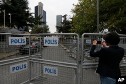 A journalist shoots video behind barriers blocking the road leading to Saudi Arabia's consulate in Istanbul, Oct. 19, 2018.