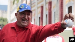 In this photo released by Miraflores Press Office, Venezuela's President Hugo Chavez jokes with a baseball at Miraflores presidential palace in Caracas, Venezuela, September 29, 2011.