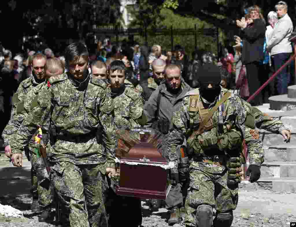 Pro-Russian gunmen carry the coffin of a person killed during last week&#39;s operation, during a commemorative service in the center of Slovyansk, eastern Ukraine, Wednesday, May 7, 2014. The U.S. and European nations have increased diplomatic efforts ahead of Ukraine&#39;s May 25 presidential election, as a pro-Russian insurgency continues to rock the country&#39;s eastern regions. (AP Photo/Darko Vojinovic)