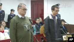 This image taken from video released on Nov. 28, 2017, by the Intermediate People's Court of Yueyang, Taiwanese activist Lee Ming-che, left, and his fellow defendant Peng Yuhua of China stand during a court session in Yueyang, Nov. 28, 2017.