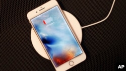 In this Sept. 15, 2017, photo, the iPhone 8 Plus rests on a wireless charger in New York. (AP Photo/Mark Lennihan)