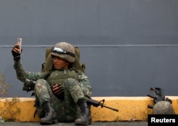 A Philippine marine soldier takes a selfie with his phone during their arrival from Marawi at port area in metro Manila, Philippines.