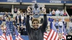 Petenis Spanyol, Rafael Nadal, mengangkat piala kemenangannya setelah memenangkan kejuaraan tenis putra Amerika Terbuka 2013 di New York, Senin (9/9).