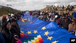 People wave a portion of a giant Bolivian naval flag on the highway between Oruro and La Paz Bolivia, March 10, 2018. A narrow strip of blue stretched for more than 120 miles (196 kilometers) across the nation Saturday as part of a demonstration of the country’s demand for an outlet to the sea.