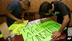 Dos jóvenes preparan en Miami carteles para una marcha en reclamo de la reforma de inmigración.