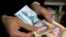 (FILE) A vendor counts money in a shop in Tehran.