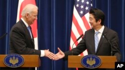 El vicepresidente Joe Biden extiende la mano al primer ministro japonés, Shinzo Abe al final de la conferencia de prensa conjunta en Tokio.