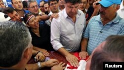 Efrain Alegre, president of the Liberal Party, and other activists react next to the casket with the remains of Rodrigo Quintana, who was killed early Saturday by a rubber bullet fired by the police in the headquarters of the Liberal Party, after clashes in Asuncion, Paraguay, April 1, 2017. 